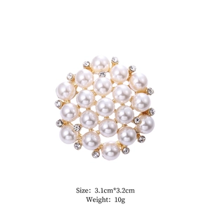 Detailed macro view of 3.1cm pearl and rhinestone flower brooch in gold finish