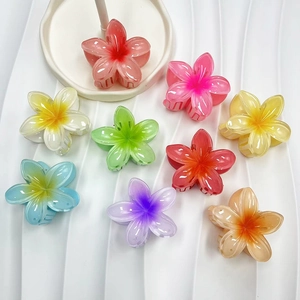 Detailed overhead view of nine gradient candy-colored frangipani flower hair claw clips