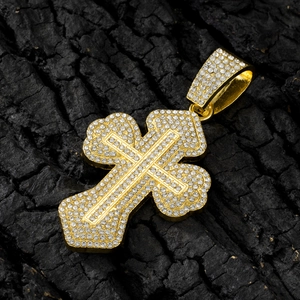 Macro shot of gold-plated iced-out cross pendant with diamonds on a dark charcoal base