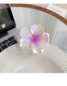 Macro detail of gradient plumeria hair claw clip with pearlescent finish on ceramic plate