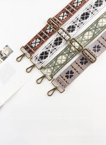 Detailed weave pattern on adjustable geometric clover shoulder straps with bronze buckles