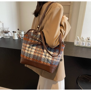 Detail shot of a plaid patchwork tote bag in brown leather on a model's shoulder