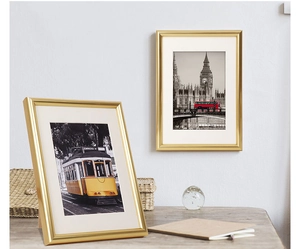 Detail of gold picture frame showing desktop stand and wall-mounted options with white matting