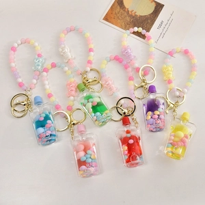 Detail of colorful acrylic liquid quicksand keychains with beads and bear charms