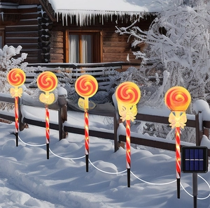 Solar outdoor candy cane stake lights with 5 red spiral LED lollipop lamps in snow