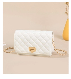 Detailed view of white quilted chain bag with gold hardware and square metal lock