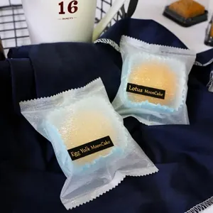 Sachets dépolis pour gâteaux de lune avec étiquettes noir et or sur nappe foncée