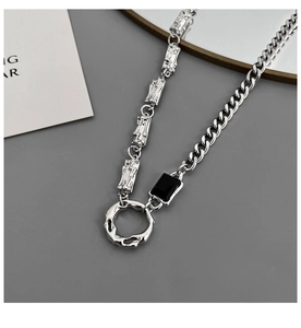 Dettaglio della collana in acciaio al titanio argento con maglie texture lava e ciondolo