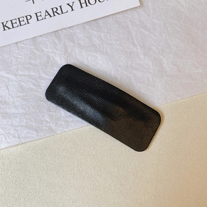 Close-up of black PU leather hair clip featuring elegant lychee grain texture and finish