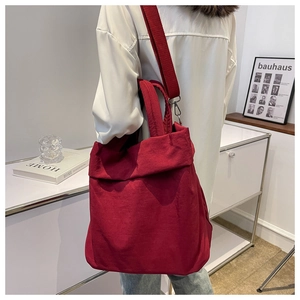 Red nylon tote bag worn by model, showing large capacity and soft structure for daily use