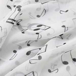 Macro detail of music note print on soft white chiffon fabric with elegant drapes