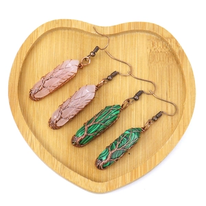 Handmade wire wrapped life tree earrings with hexagonal crystal stones in a wooden tray
