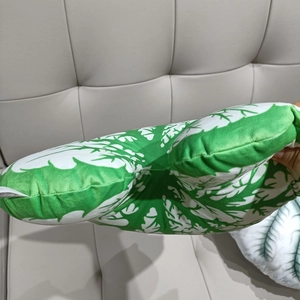 Detail showing the thick plush texture and leaf pattern of this green plant pillow
