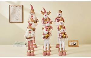 Detailed view of pink and gold sequin Christmas dolls including Santa, reindeer, and snowman