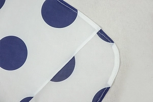 Close-up of white fabric with blue polka dots showing high-quality stitching and hem