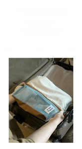 Detailed view of travel storage bag with mesh window and zipper in a suitcase