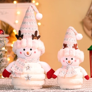Pair of plush Christmas snowmen with pink knit hats and brown antlers in festive warm setting