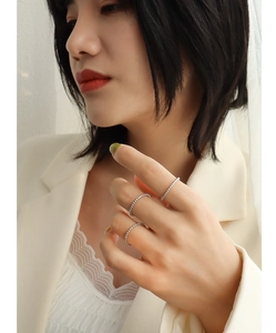 Detailed view of silver beaded rings set on model hands with elegant fashion outfit