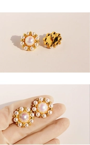 Detailed view of vintage pearl flower earrings featuring central baroque pearls and gold tone
