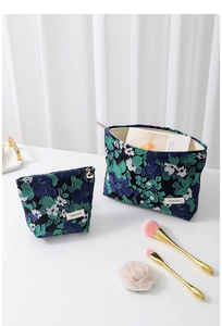Detail of floral jacquard cosmetic bag set with H&R label on white table setting
