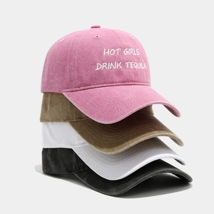Detail of embroidered washed cotton baseball caps in pink, tan, white, and charcoal colors