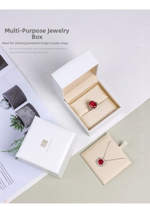 Detail of premium white jewelry box with gold logo and beige velvet interior for rings
