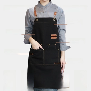 Detail of waterproof black canvas apron with brown leather straps and metal rivets