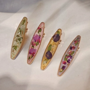 Handmade resin hair clips with real dried flowers and gold foil accents in four colors