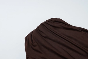 Close-up of deep brown pleated knit fabric texture and high-quality stitched detail