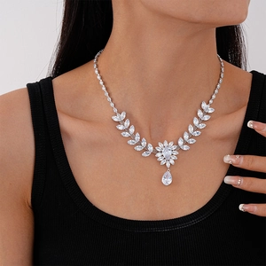 Gros plan du collier feuilles en zircon avec pendentif goutte sur modèle de mariée