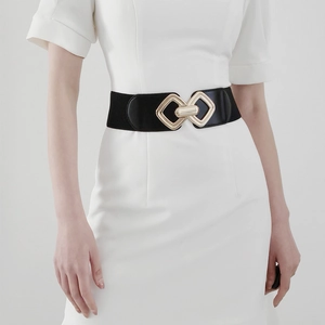 Gros plan sur ceinture large élastique noire avec boucle géométrique dorée élégante