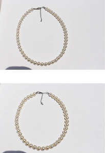 Close-up of white round pearl necklace with silver adjustable lobster clasp closure