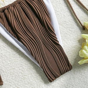 Close-up of brown pleated bikini bottoms featuring side ties and delicate texture