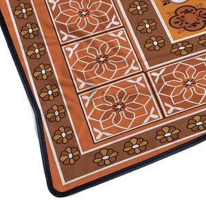 Close-up of soft flannel blanket with vintage orange floral pattern and durable stitched edges