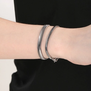 Silver flat snake chain bracelet set on wrist showing sleek metallic luster