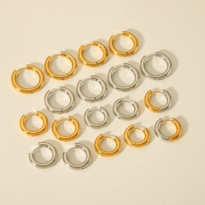 Flat lay of bold stainless steel hoop earrings in various sizes and metallic finishes