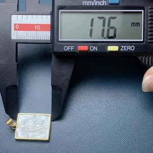 Macro shot showing the 17.6mm width measurement of the golden Guadalupe pendant