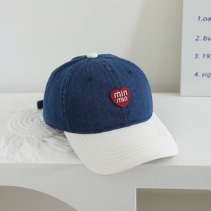 Detail of red heart embroidery with min min text on a two-tone denim baseball cap