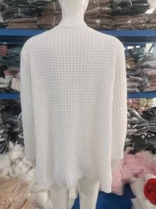 Dettaglio del cardigan bianco in maglia a nido d'ape con polsini a coste sul retro