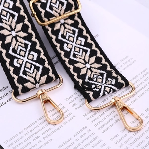 Detail of ethnic style woven bag strap with black-and-white pattern and gold lobster clasp