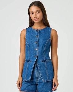 Dettaglio di un gilet di jeans senza maniche con bottoni in metallo e shorts coordinati