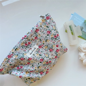 Macro shot of floral cotton cosmetic bag with pink roses and simple wish label