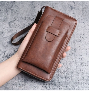 Detail of a brown leather long wallet with wrist strap and front phone pocket for men