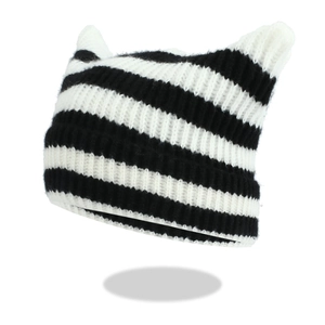 Close-up of black and white striped knit beanie with cute cat ear design and soft texture