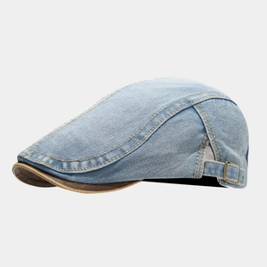 Detail der gewaschenen Jeans-Schiebermütze mit gelben Nähten und brauner Lederpaspel