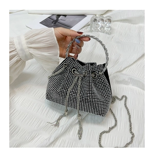 Detail of black rhinestone bucket bag featuring silver ring handle and chain strap