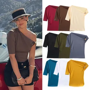 Detail of off-shoulder summer top featuring unique metal ring buckle on the neckline