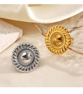Close-up of retro sunburst textured round ring in gold and silver stainless steel