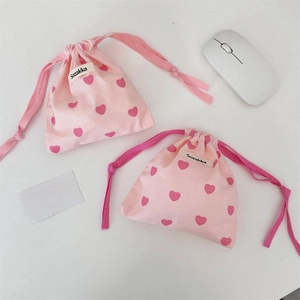 Detail of pink cotton drawstring bags with red heart pattern and Sozakka brand tag