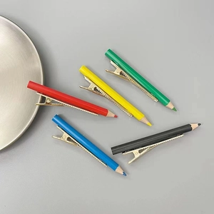 Vue détaillée de pinces à cheveux colorées en forme de crayon en rouge, jaune et bleu